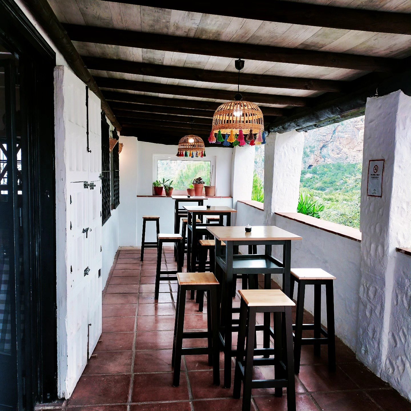 Pasillo de entrada del restaurante La Grulla con paredes blancas y vigas de madera